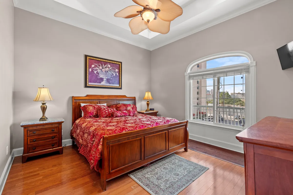 A cozy bedroom with a well-made bed, soft lighting, a nightstand with a lamp, a dresser, and a window letting in gentle morning light. The neutral tones and carefully chosen artwork create a calm and inviting atmosphere, perfect for restful sleep.